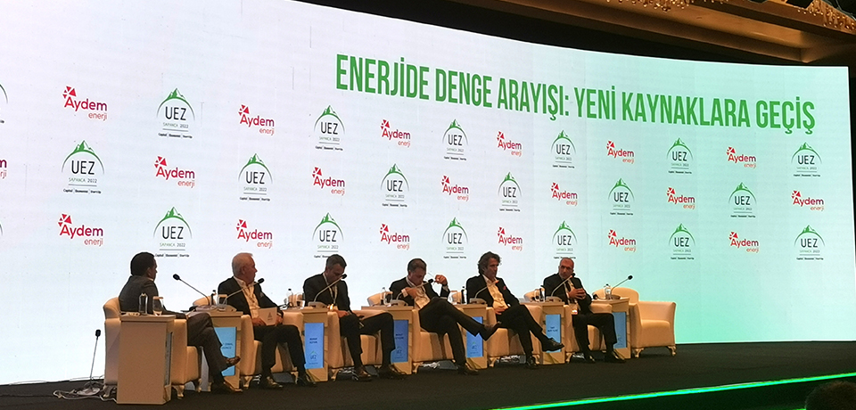 Aydem Enerji'nin Uludağ Ekonomi Zirvesi'nde sponsoru olduğu Enerjide Denge Arayışı: Yeni Kaynaklara Geçiş" panelinde yapılan konuşma sırasında çekilen sahne fotoğrafı yer almaktadır. 